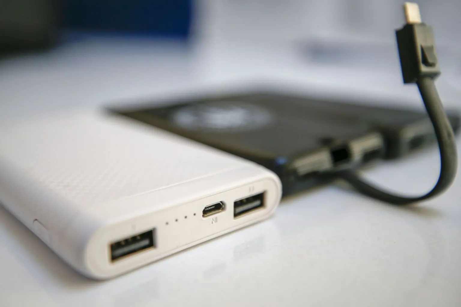 Anadolu Agency/ White and black portable chargers.