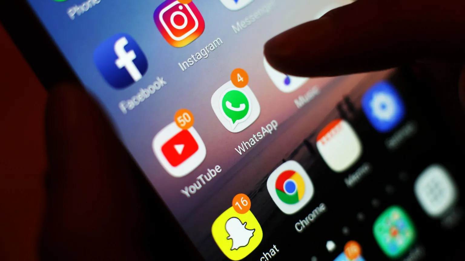 A close up of a smartphone with a number of social media apps including YouTube, Snapchat and WhatsApp