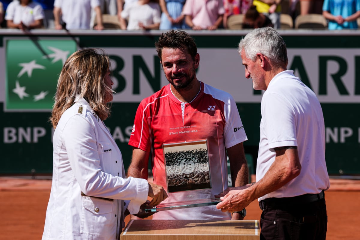 Stan Wawrinka receives a trophy to mark his retirement from Amélie Mauresmo (left) and Gilles Moretton (right).