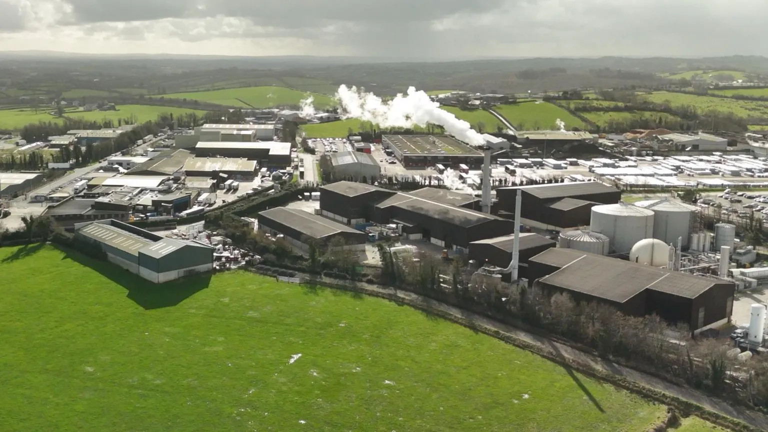 An aerial shot of Granville Industrial Estate showing a range of industrial buildings and a chimney with smoke or steam coming out of it.