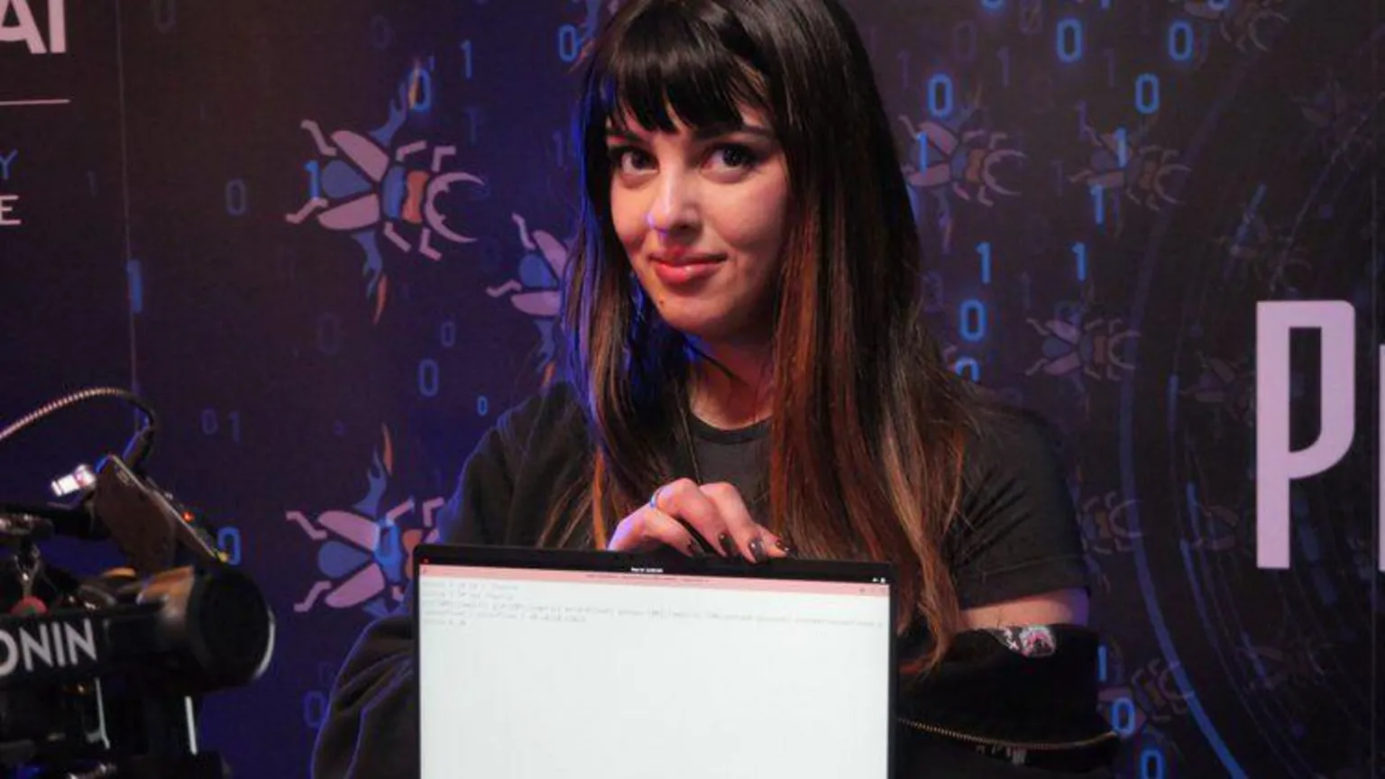 Trend AI Zero Day Initiative Chompie the hacker holding up a laptop showing the screen