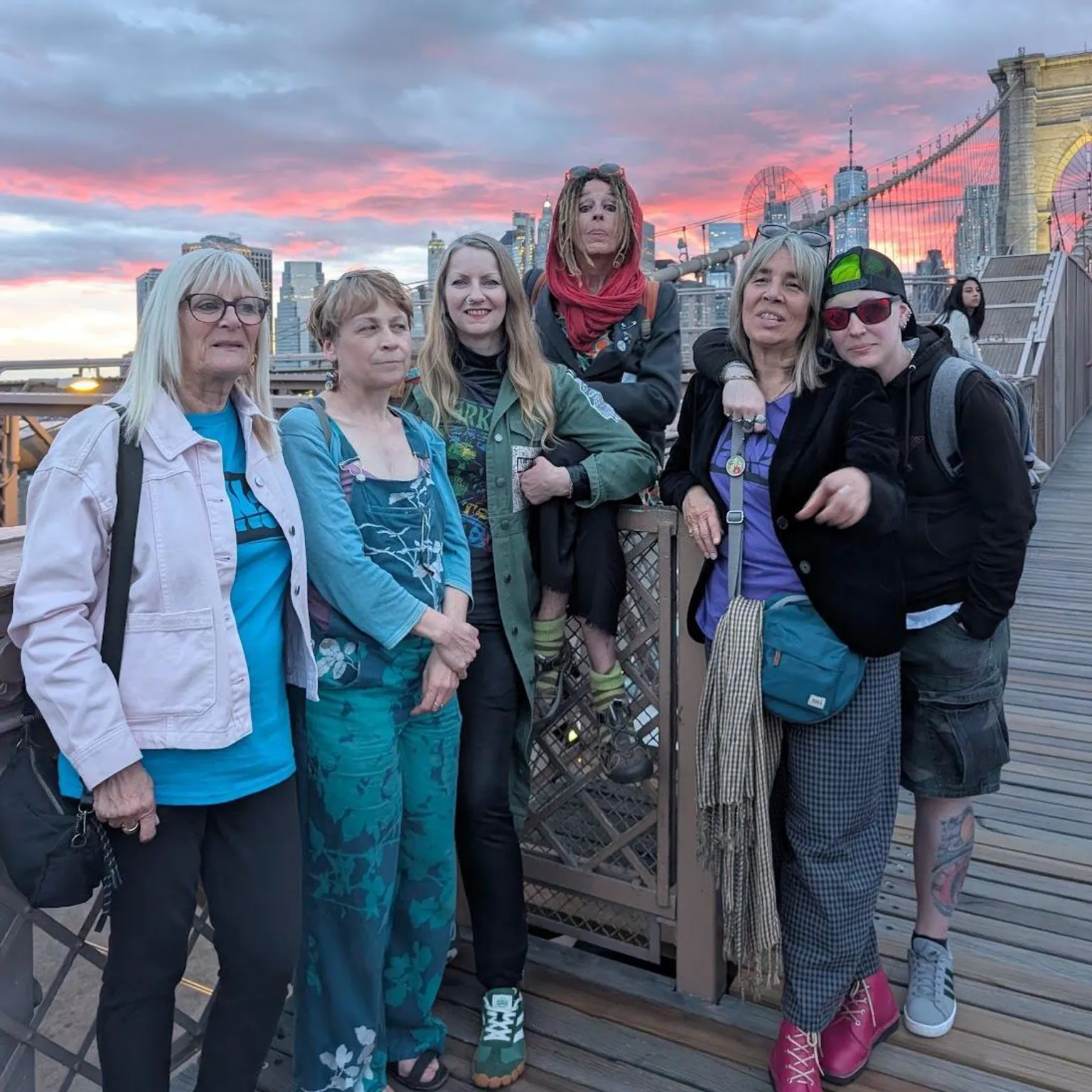 Nan Davies / Laura Robinson / BBC Six women stood on a bridge with a pink sky behind them