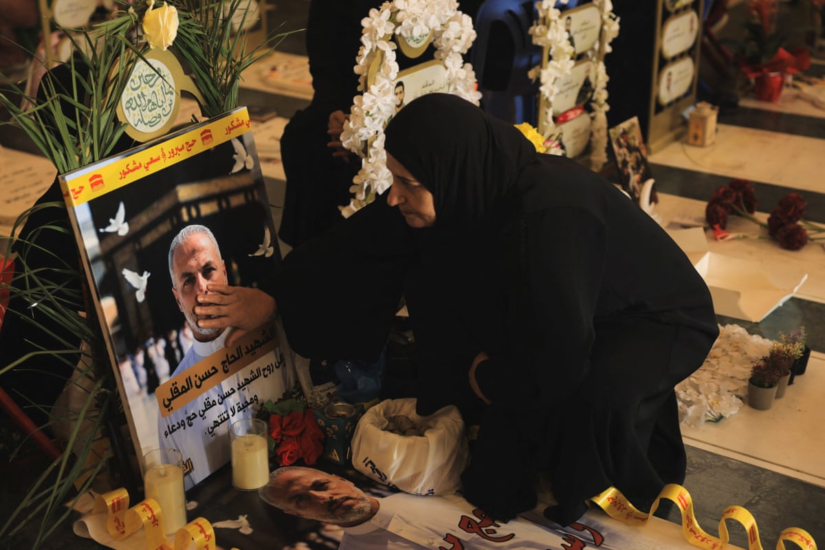 A woman touches a photo of a man on a gravestone.