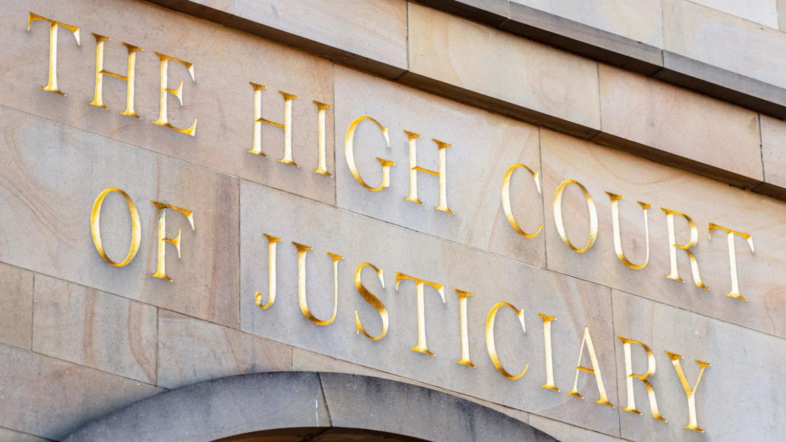 A wall with gold letters saying The High Court of Justiciary