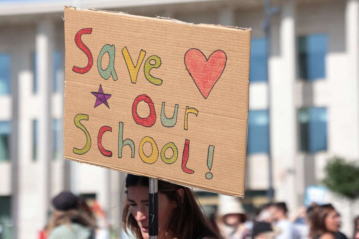 A homemade placard reading ‘Save our school’