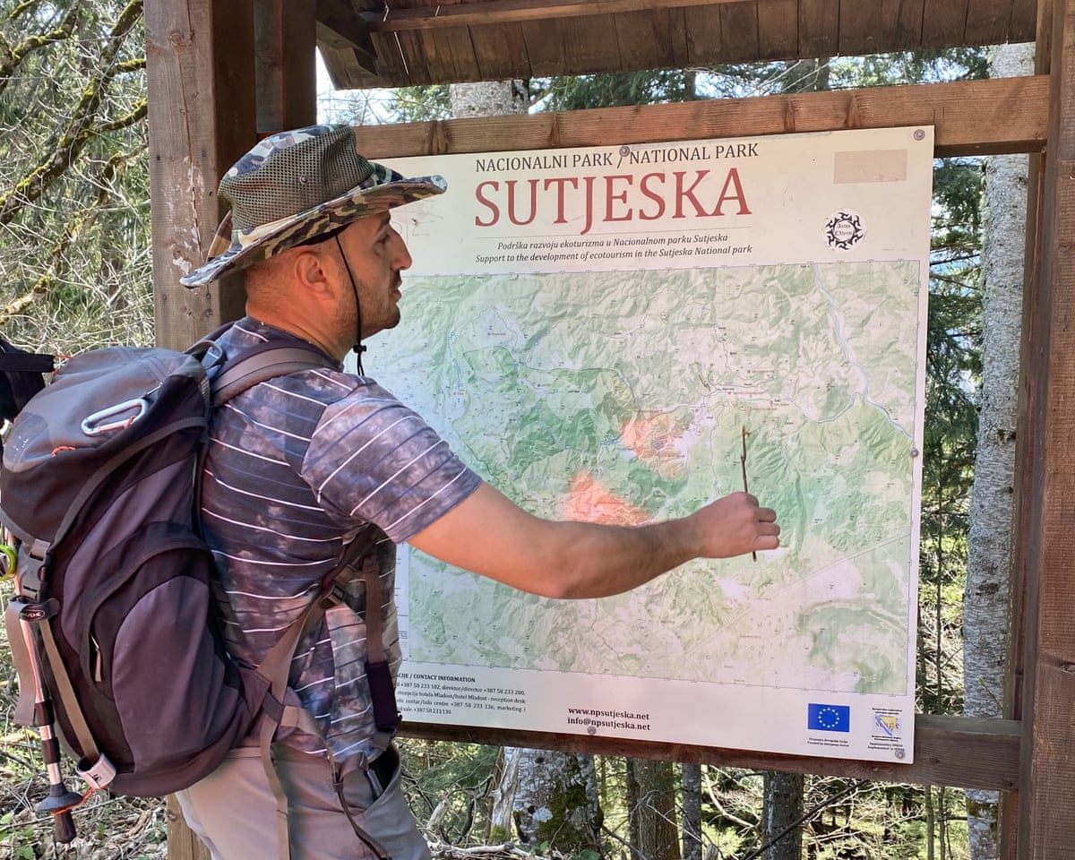 Man with backpack looks at a map