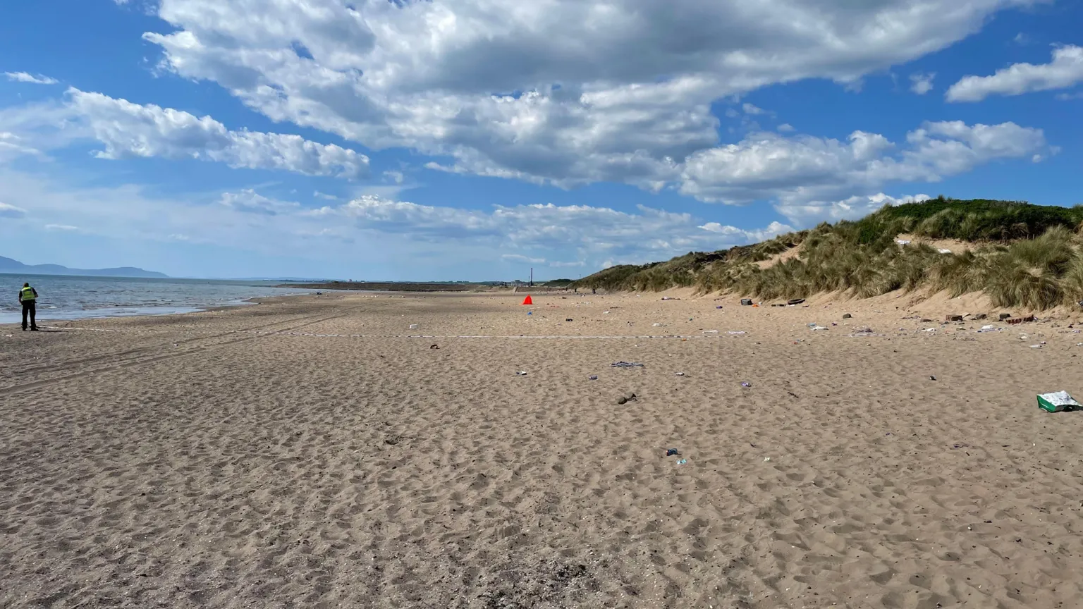 A general view of Irvine Beach with a police officer and police tape on the scene.