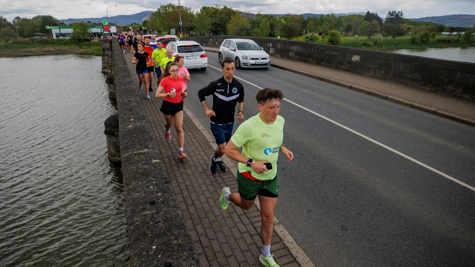  A group of people running over a bridge.