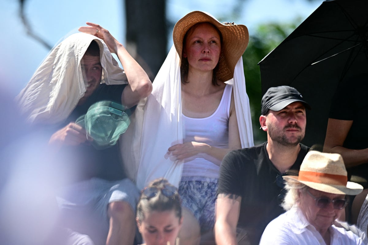 Spectators hide from the sun as they watch Iva Jovic against Emma Navarro.