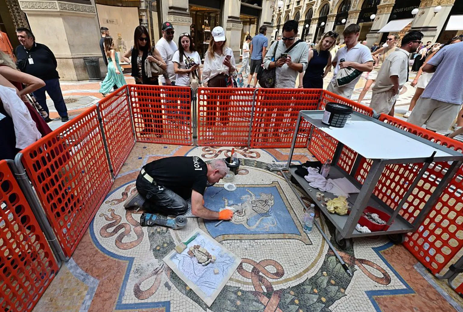 Stefano Rellandini/AFP via Restorer Gianluca Galli works on the mosaic of the bull during the restoration in the Galleria Vittorio Emanuele II, in Milan on 28 May 2026.