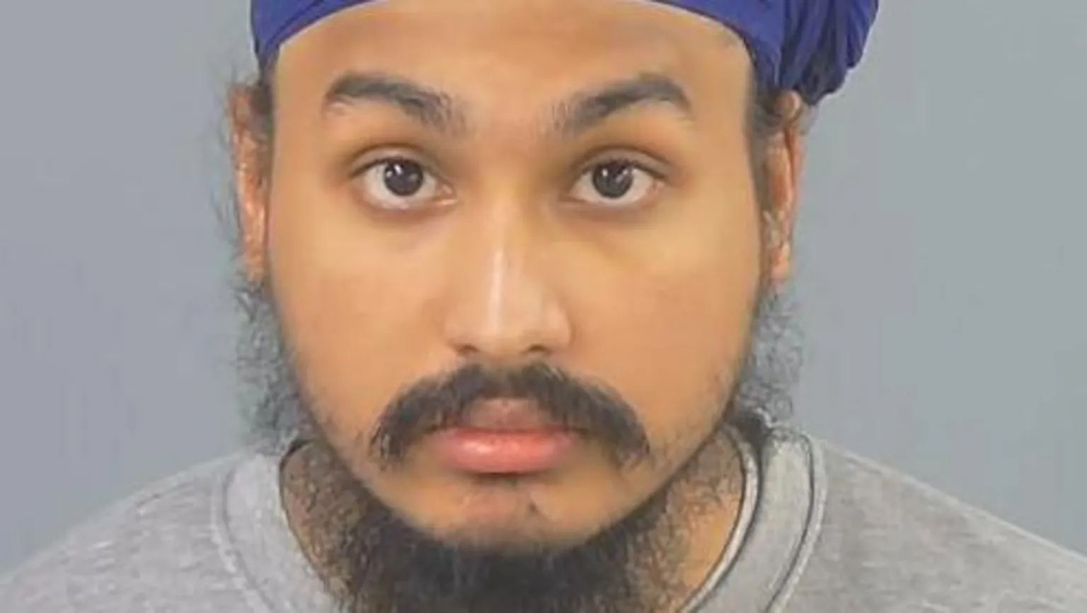 Police handout Custody photo of Vickrum Digwa, a man with a beard, a grey jumper and a purple turban looking to the camera.