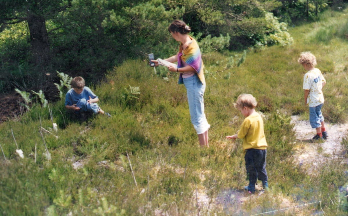A family snapshot of a woman and three small children in scrubland