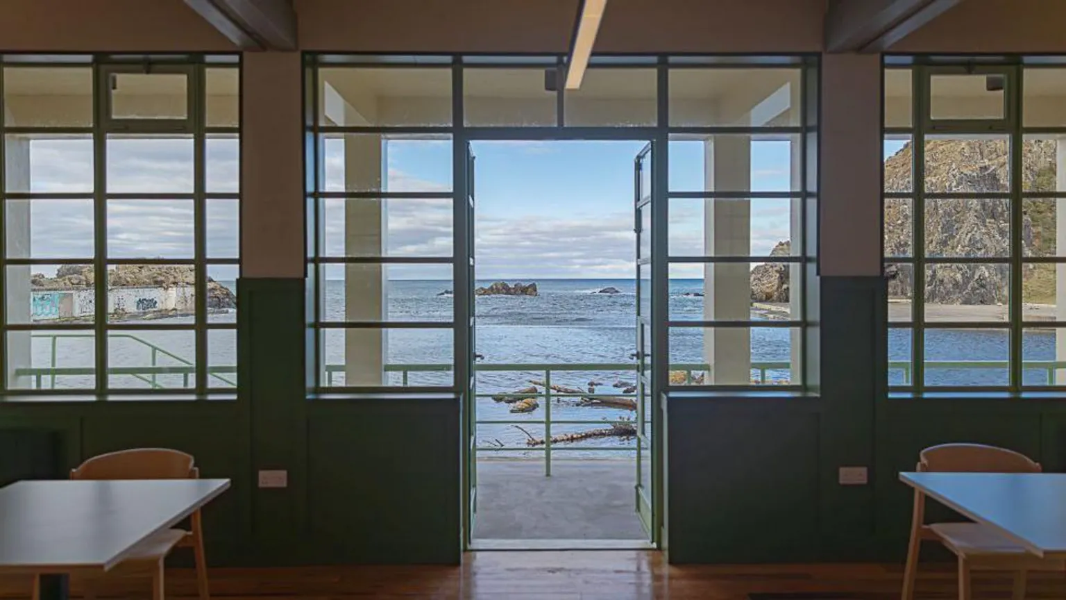 James Kerr An open air pool can be seen, taken from inside a restored pavilion building.