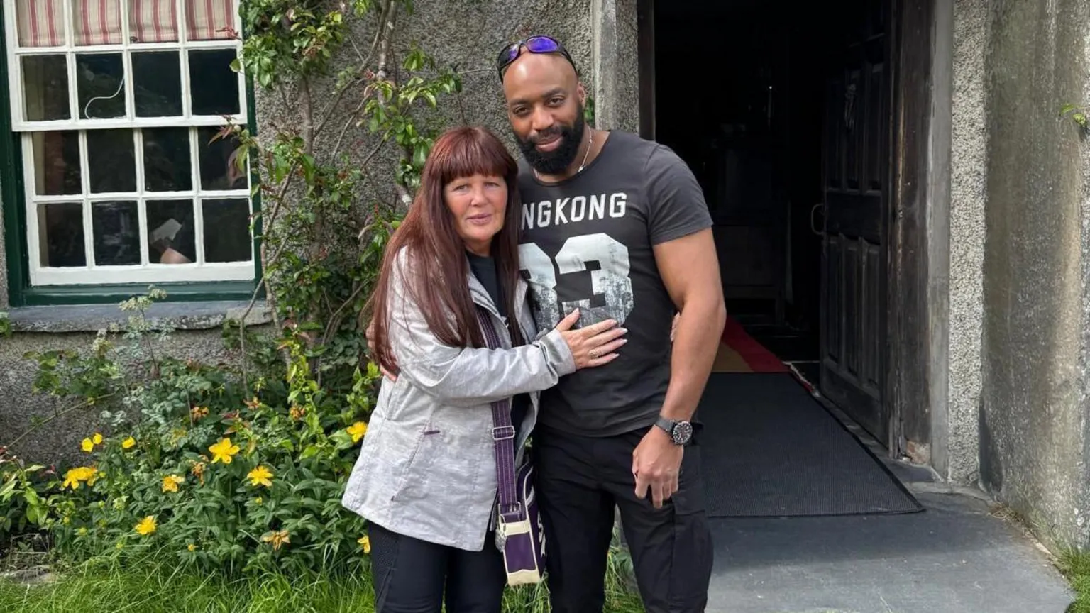 GMP Denise, with red hair and a light blue jacket, with her arms around her partner Sylvester Abayomi, wearing a black T-Shirt with white numbers and with sunglasses on his head, in a photo released by the family.