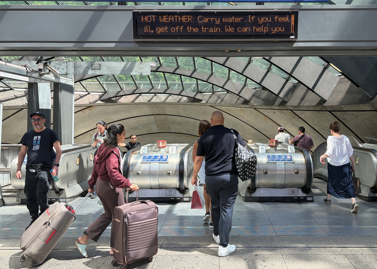 Commuters are warned about the hot weather outside the Canary Wharf station in London.