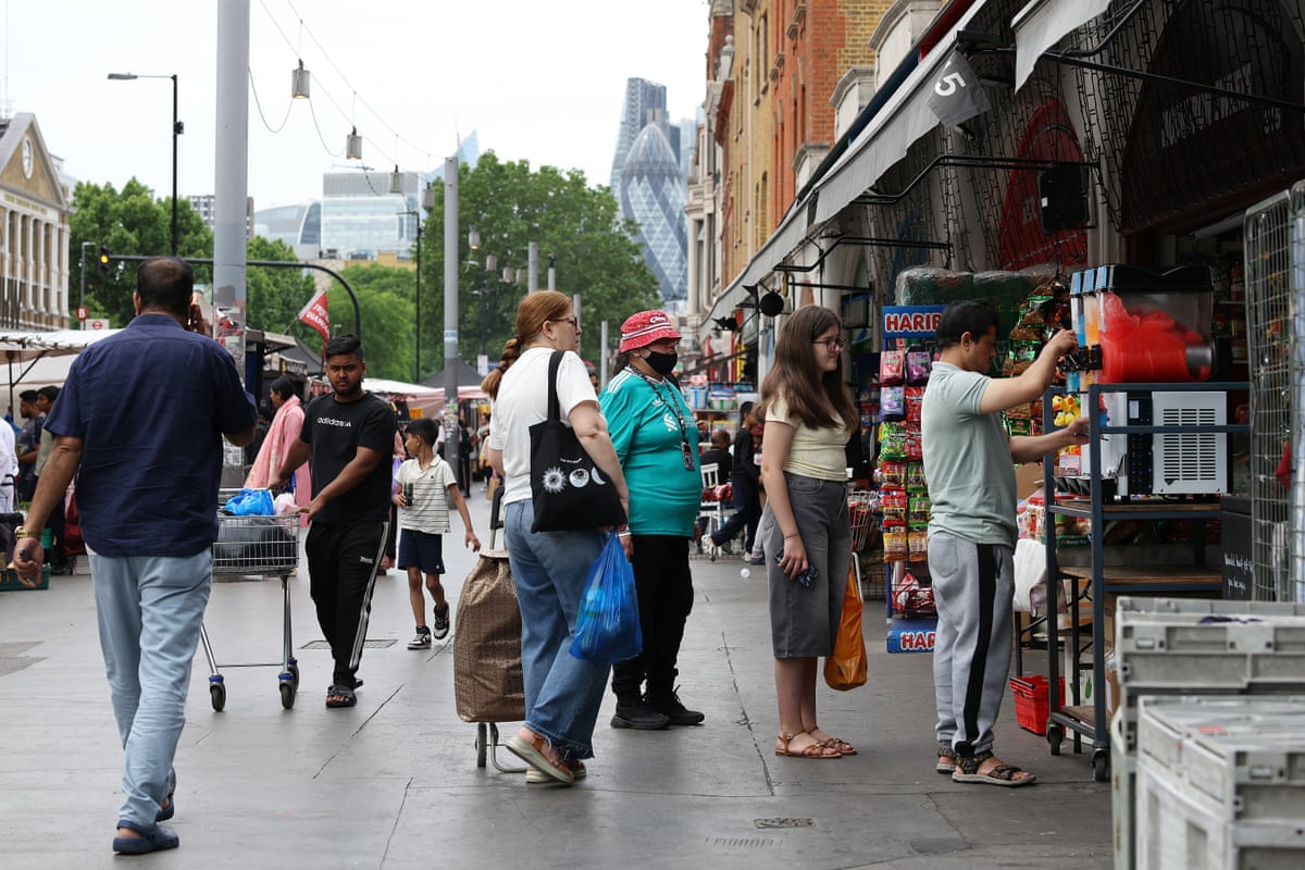 People queue for ice drinks on a high street in London during a heatwave 