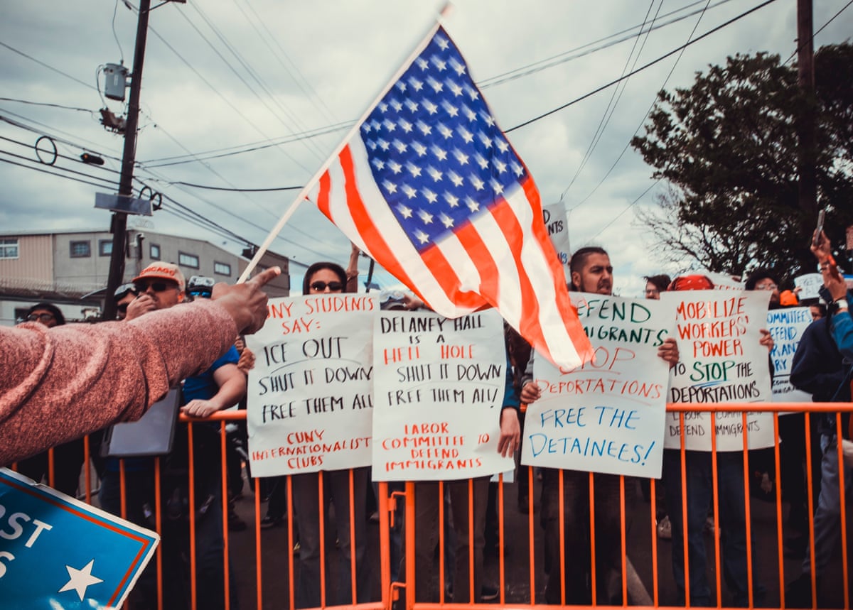 A rightwing counterprotester holds a flag as they face off against anti-ICE protesters in front of Delaney Hall detention facility, in New Jersey, on Saturday.