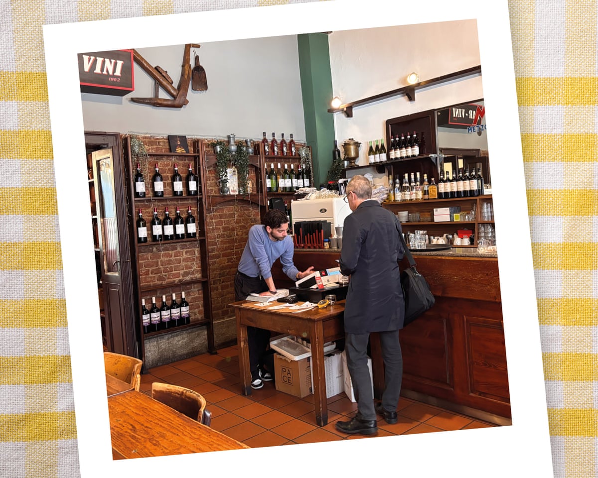 Two men, customer and waiting staff, in a wine bar/restaurant