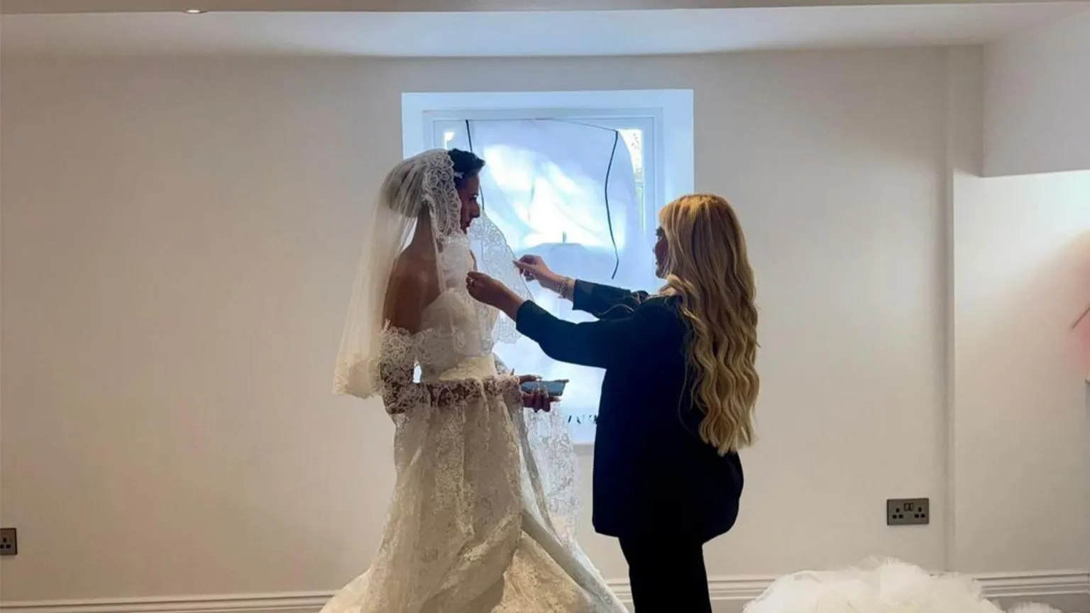 Lynsey Austin A blonde woman styling a woman in a wedding dress.