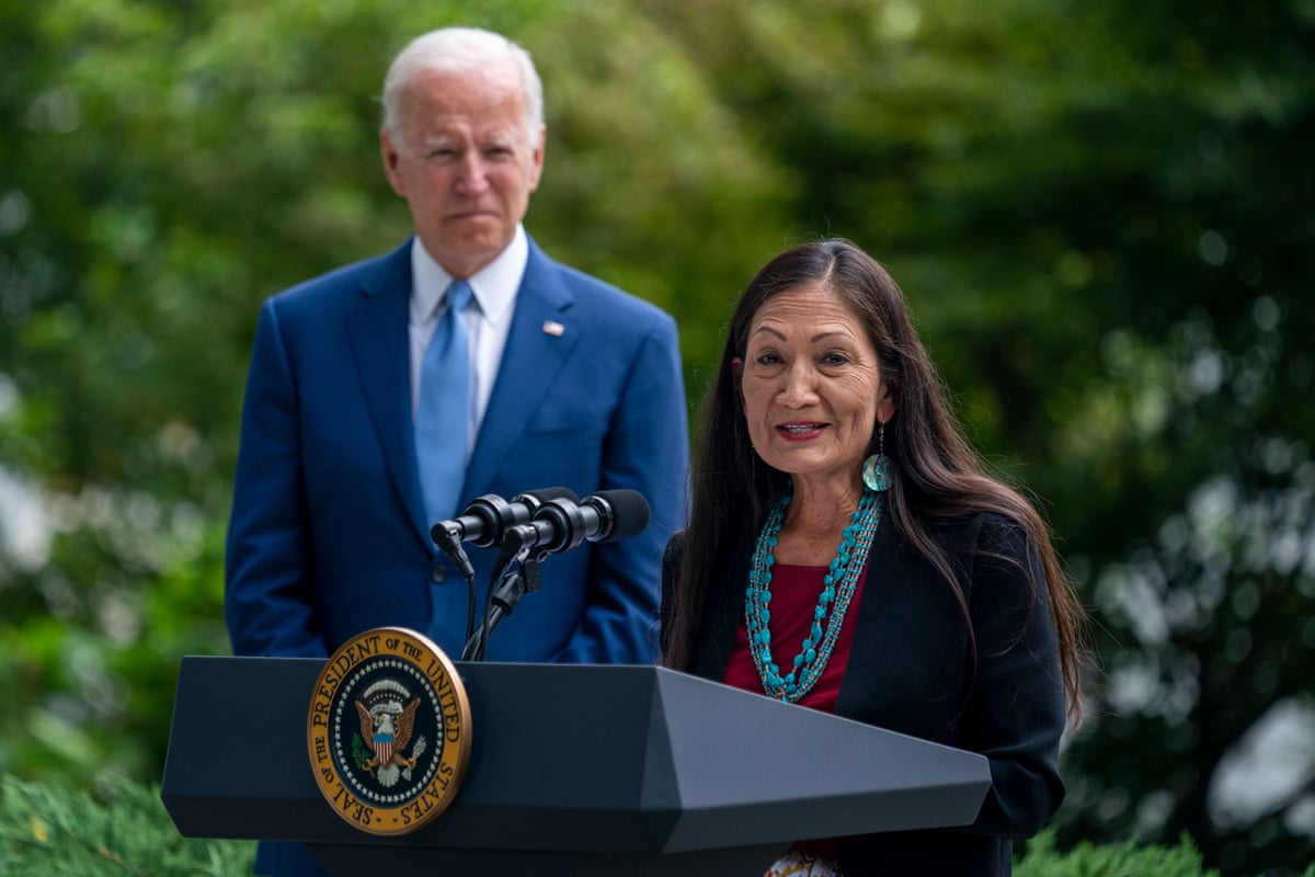 United States President Joe Biden looks on as US Secretary of the Interior Deb Haaland delivers remarks during a signing ceremony to restore and protect 3 national monuments on the North Lawn of the White House in Washington, DC.