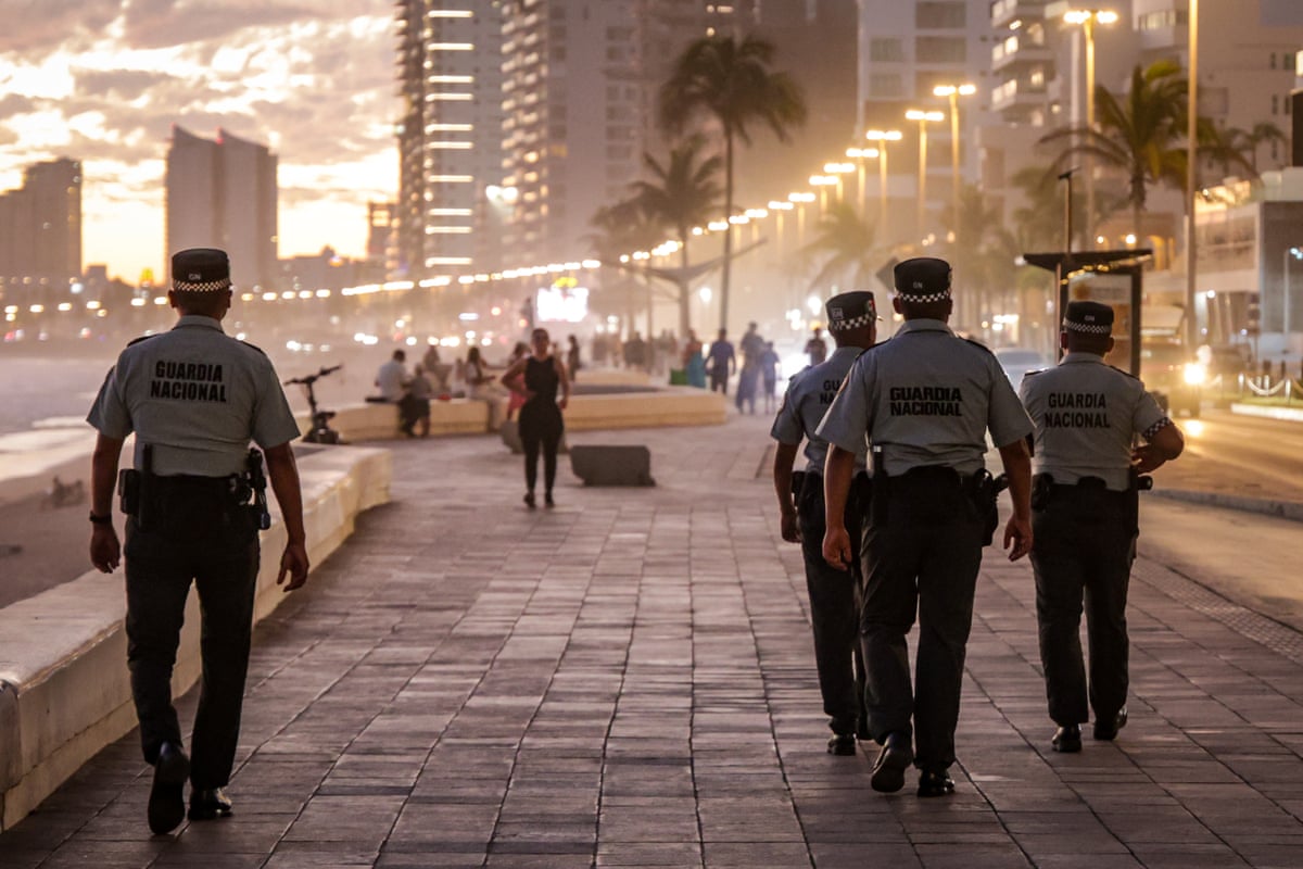 Officers photograhed from behind walking down street in Sinaloa, Mexico.