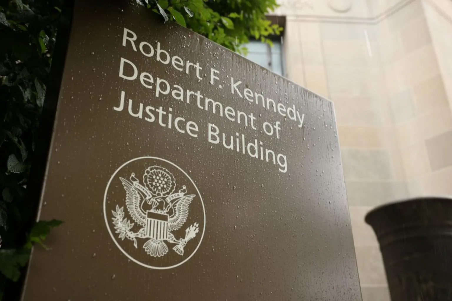The sign outside the DOJ is brown with an insignia. Its words say: