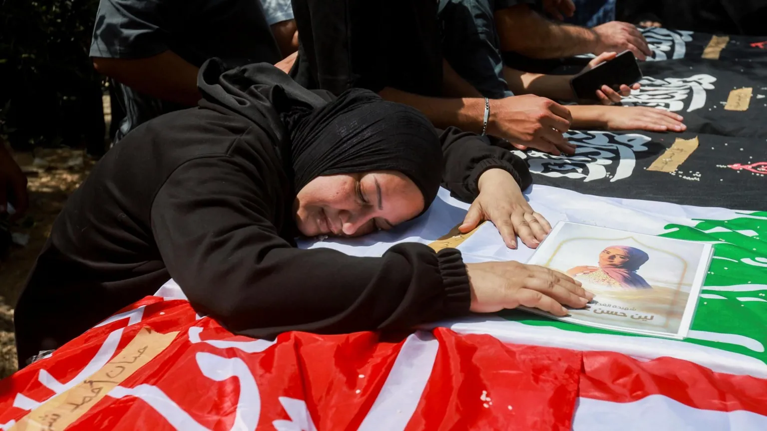  A woman leans over a casket during the funeral of two parents and their four children in an Israeli strike, in Wardaniyeh, Lebanon (3 June 2026).