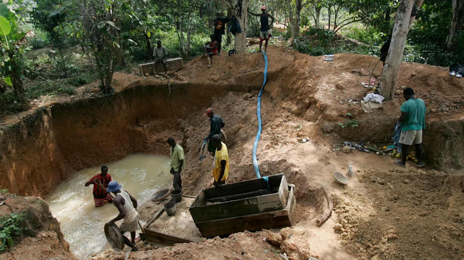 AFP via An informal diamond mine in Sierra Leone, with men sieving for the gems in a big pool of water