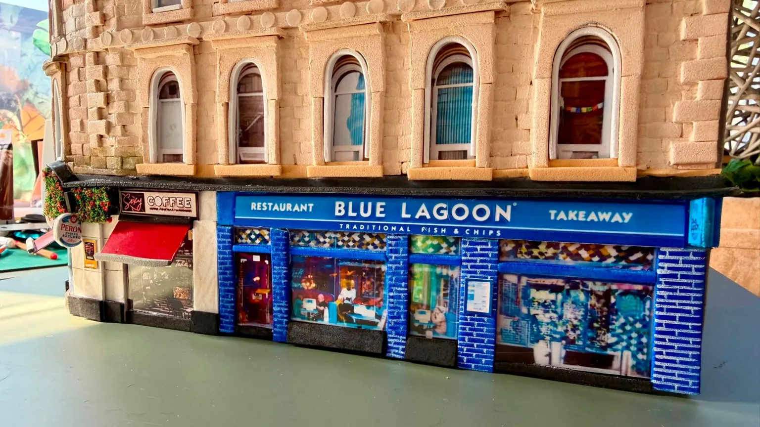 Karen Bones A cardboard model of Union Corner. It is a Victorian Building with colourful shop fronts on the ground floor.