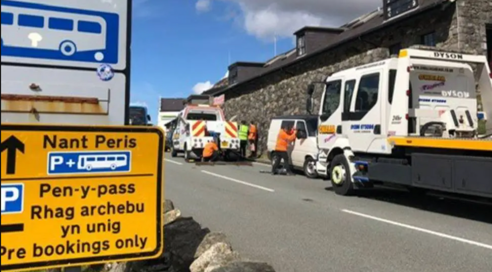 Cerbydau wedi eu parcio yn groes i'r rheolau yn ardal Pen y Pass yn cael eu tywys i ffwrdd (llun o 2023)