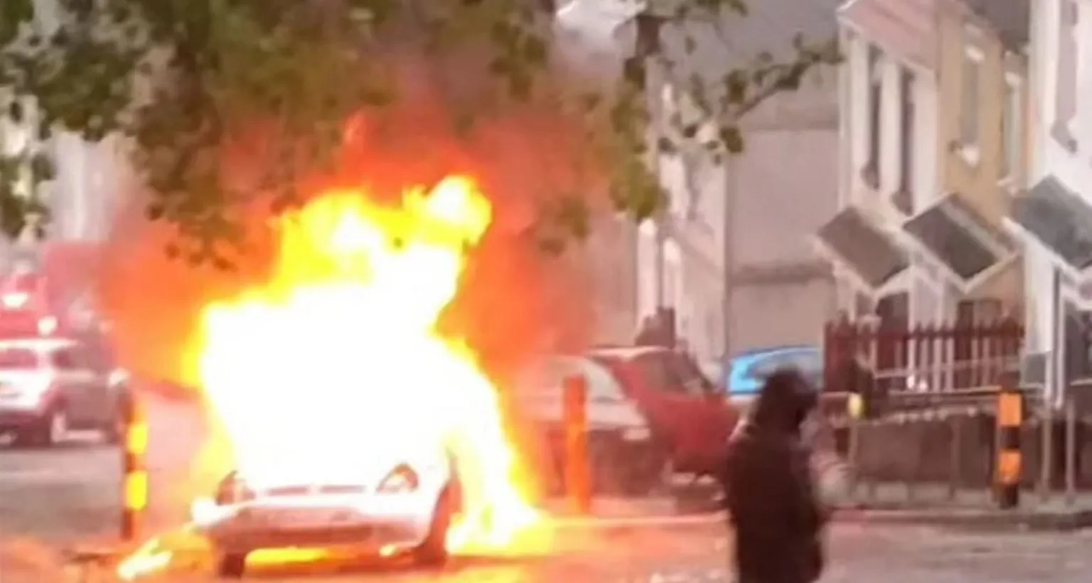 Social media A car set alight in front of several terraced houses
