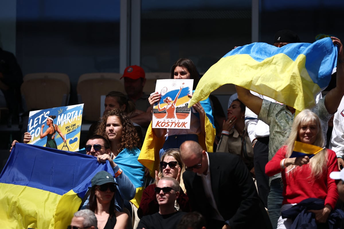 Marta Kostyuk fans hold Ukrainian flags in the stands during her semi-final match.