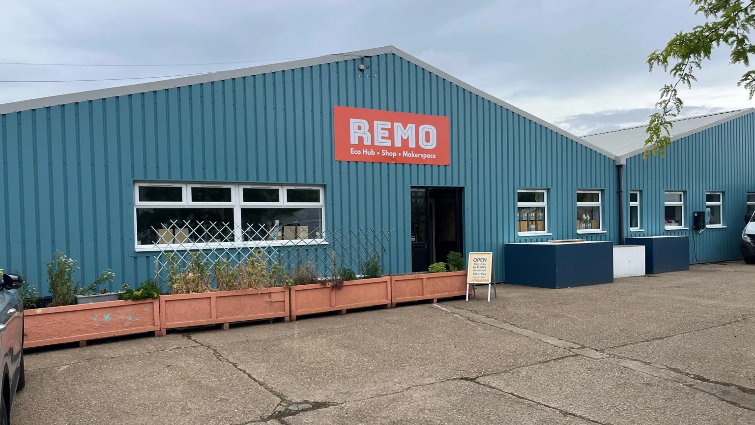 John Devine/BBC The outside of a light blue building with cladding metal cladding and two apex roofs. The sign above the door reads 
