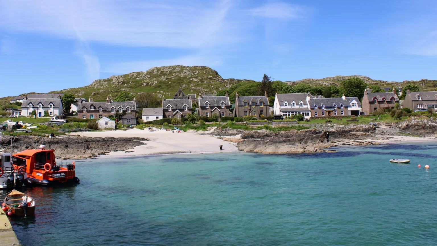Tanja Vayrynen A coastal village. Houses overlook the clear the beach and clear water. 