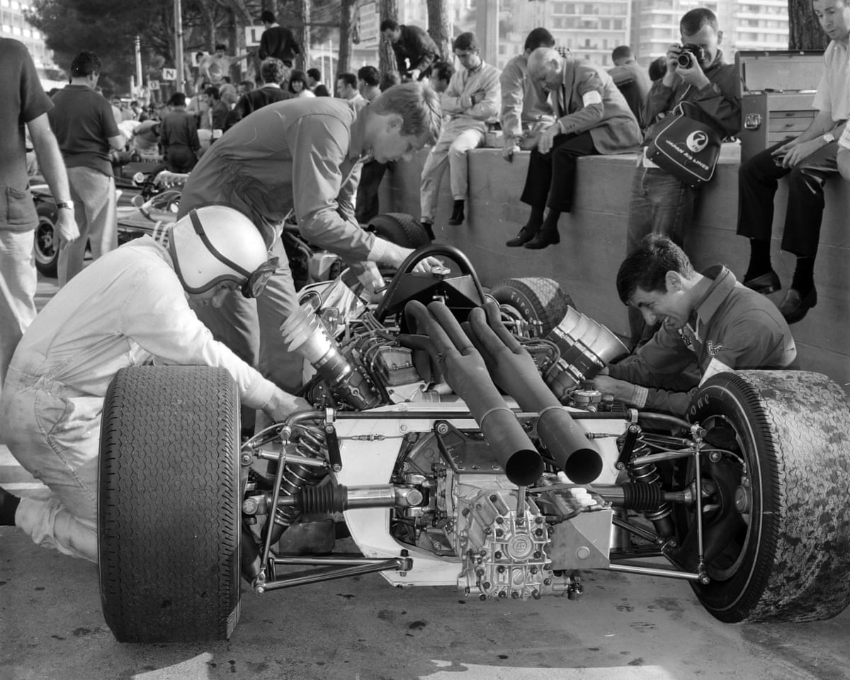 Bruce McLaren works with mechanics on his McLaren M2B Ford ahead of the team's debut at Monaco in 1966.