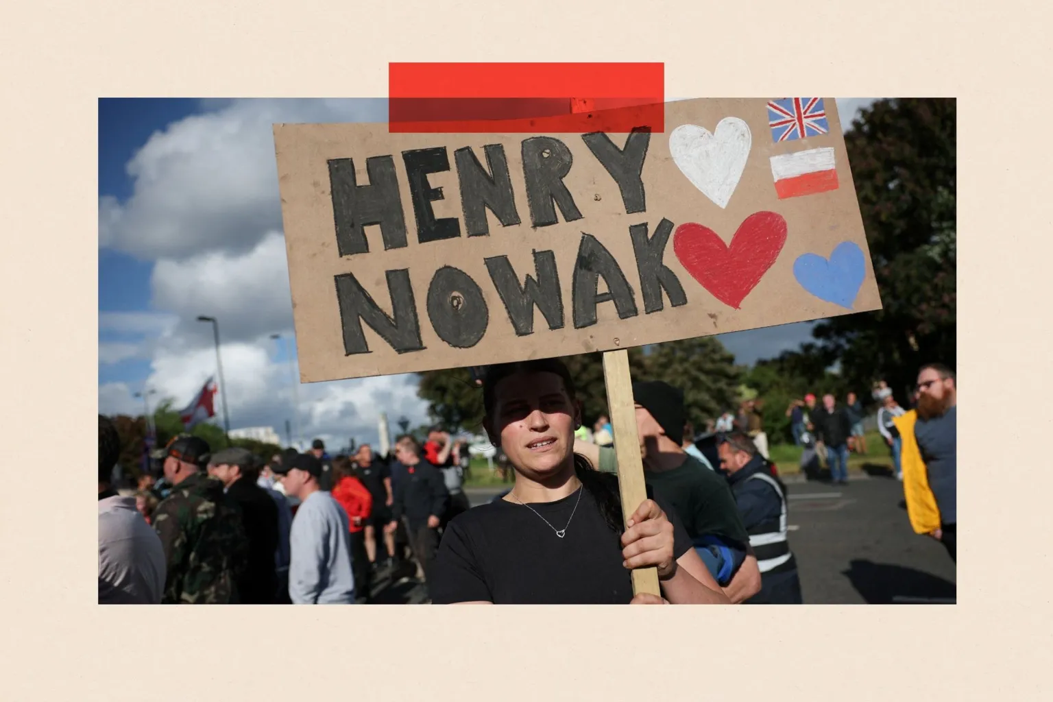 A demonstrator holds a placard that reads: Henry Nowak