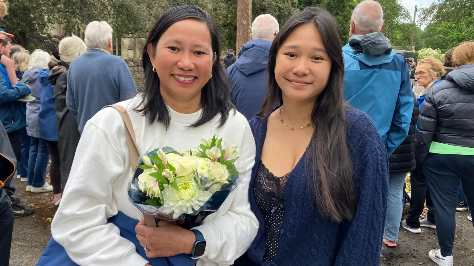 A mum and her daughter are pictured, one is holding flowers.