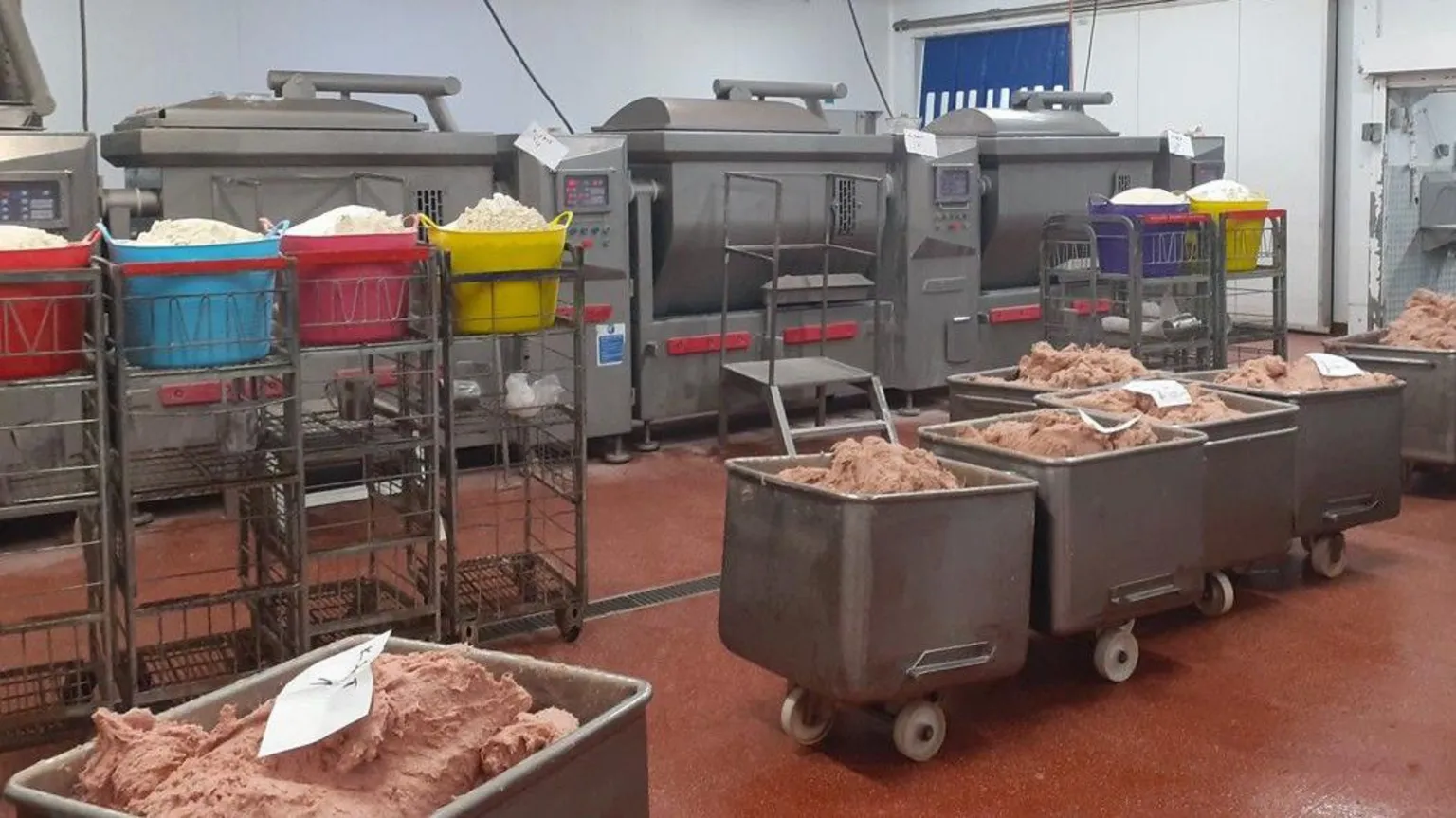 Media Wales Interior of factory with raw meat in large stainless steel containers on wheels and machines on factory floor