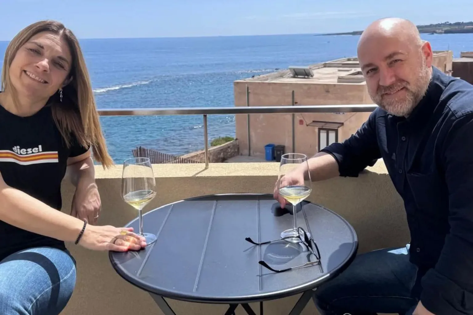 Alan Weir Piera and Alan sitting outside at a table with glasses of drink.