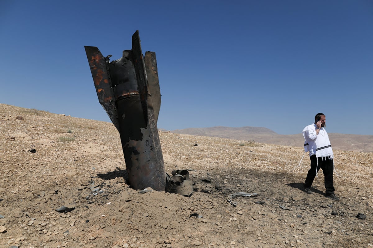 Part of a missile protrudes from the ground, following strikes from Iran, in the Israeli-occupied West Bank.