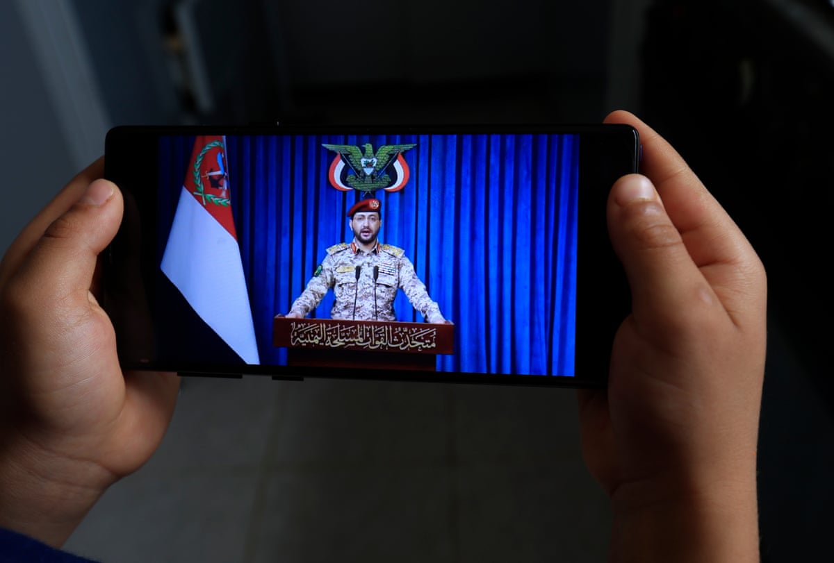 A phone displaying Houthi military spokesperson Yahya Sarea delivering a statement in Sana’a, Yemen, as the group says they will ban all Israeli maritime navigation in the Red Sea.