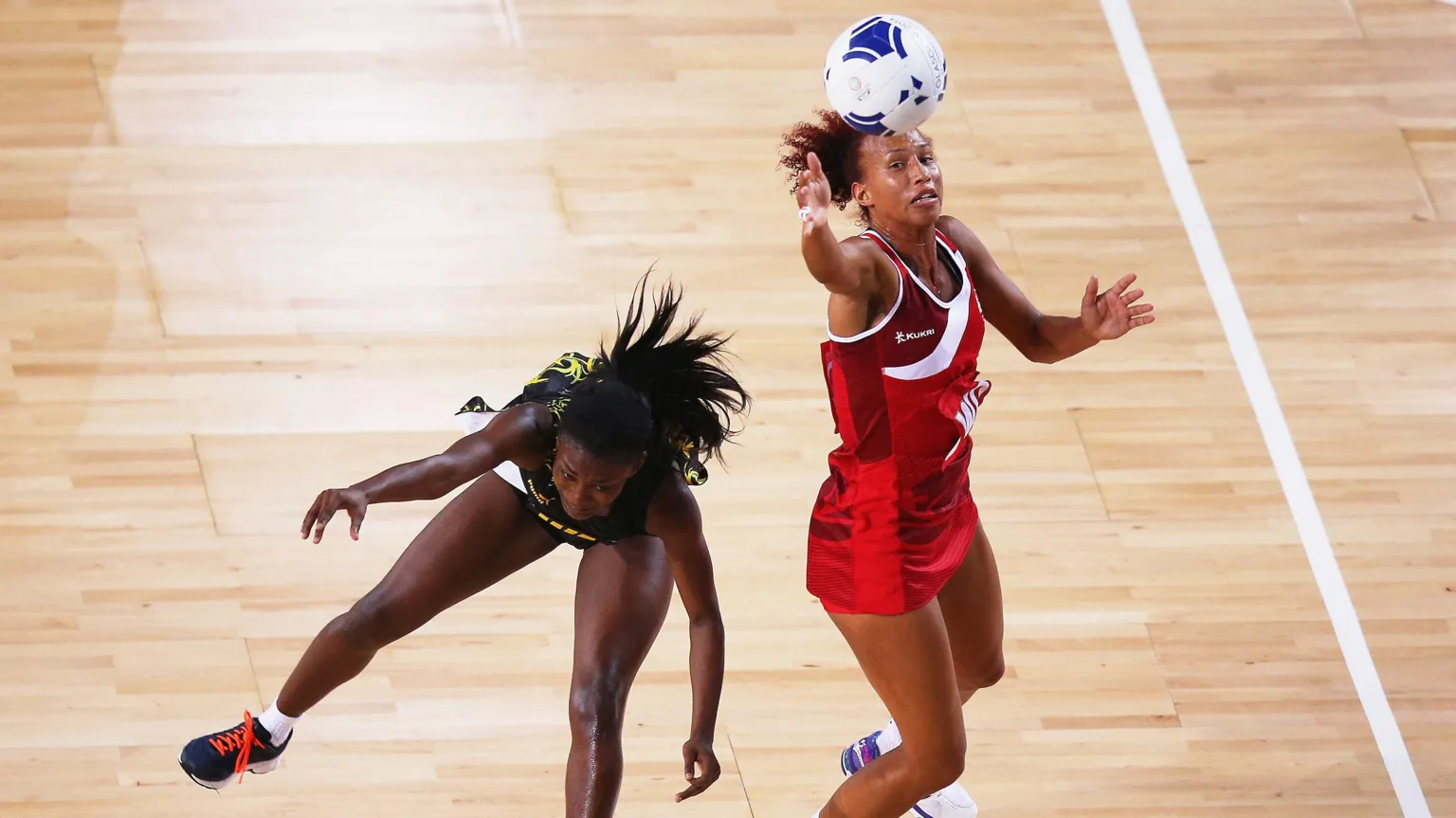 Serena Guthrie pictured in an action shot playing netball. Another player is visible and Guthrie is winning possession of the ball.