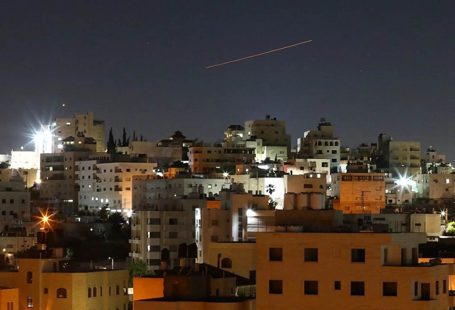 Anadolu via Missiles launched from Iran toward Israel are seen in the sky over the West Bank city of Hebron on 7 June.
