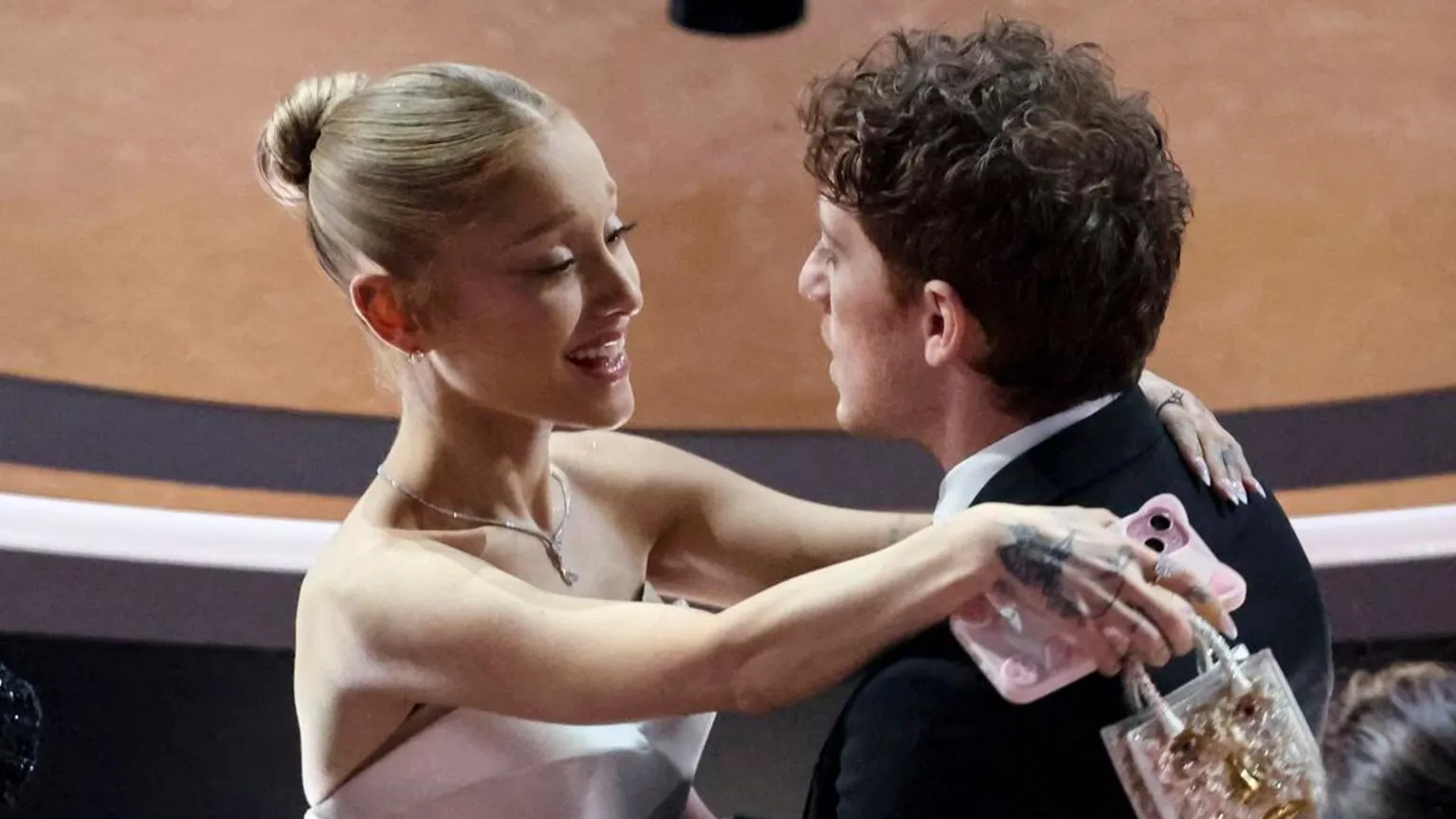 Ariana Grande embarces Ethan Slater at the Oscars ceremony last year
