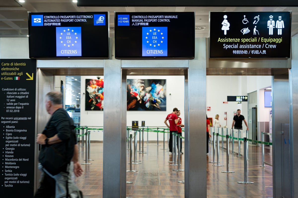 Passport control gates at Venice airport, with screens indicating lanes for EU and other passport holders.