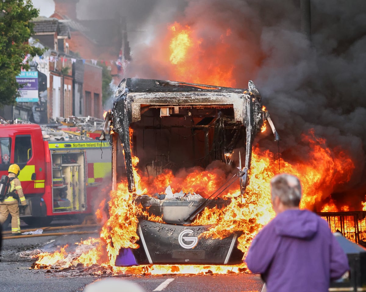 Firefighters next to burning bus