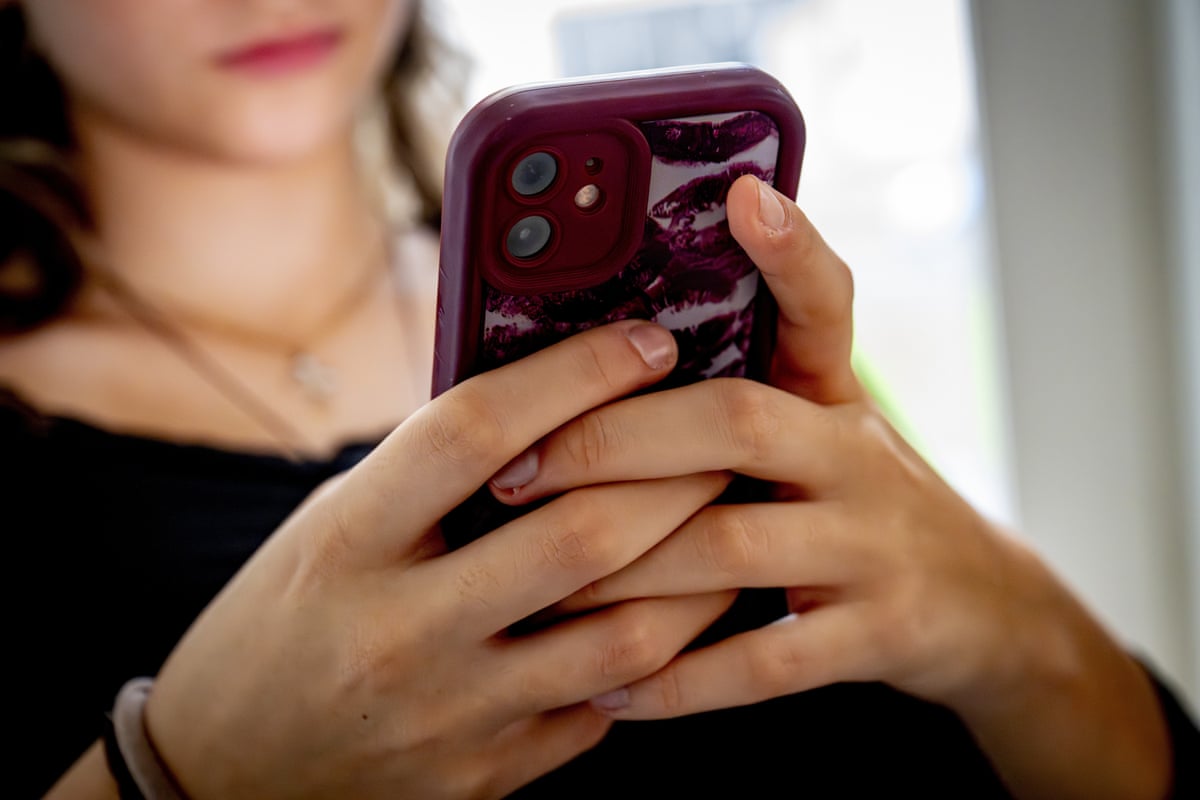 A woman holds a mobile phone