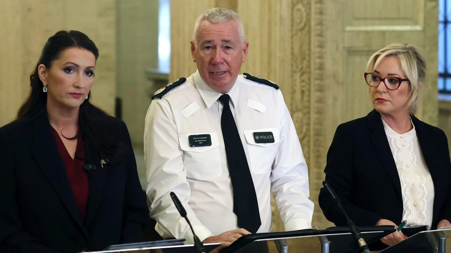 Emma Little Pengelly, Jon Boutcher and Michelle O'Neill stand side by side at a podium in Stormont