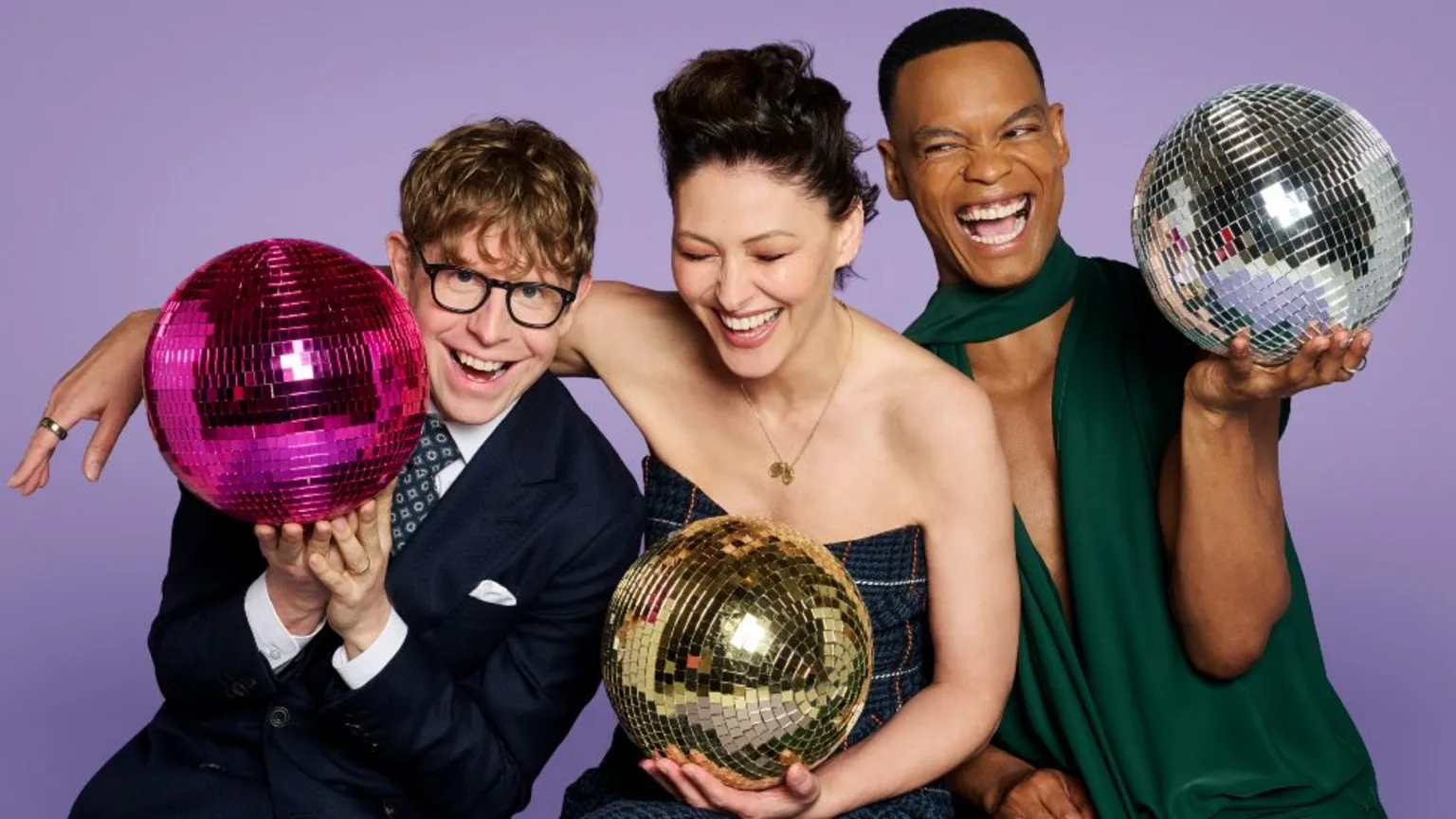 Josh Widdicombe, Emma Willis and Johannes Radebe holding glitter balls against a purple background