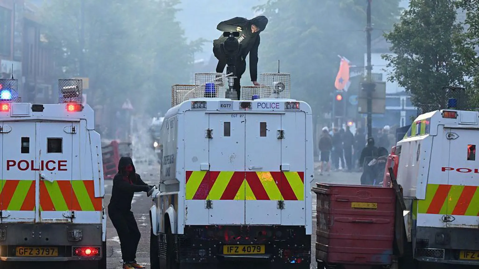  A man on top of police Land Rover